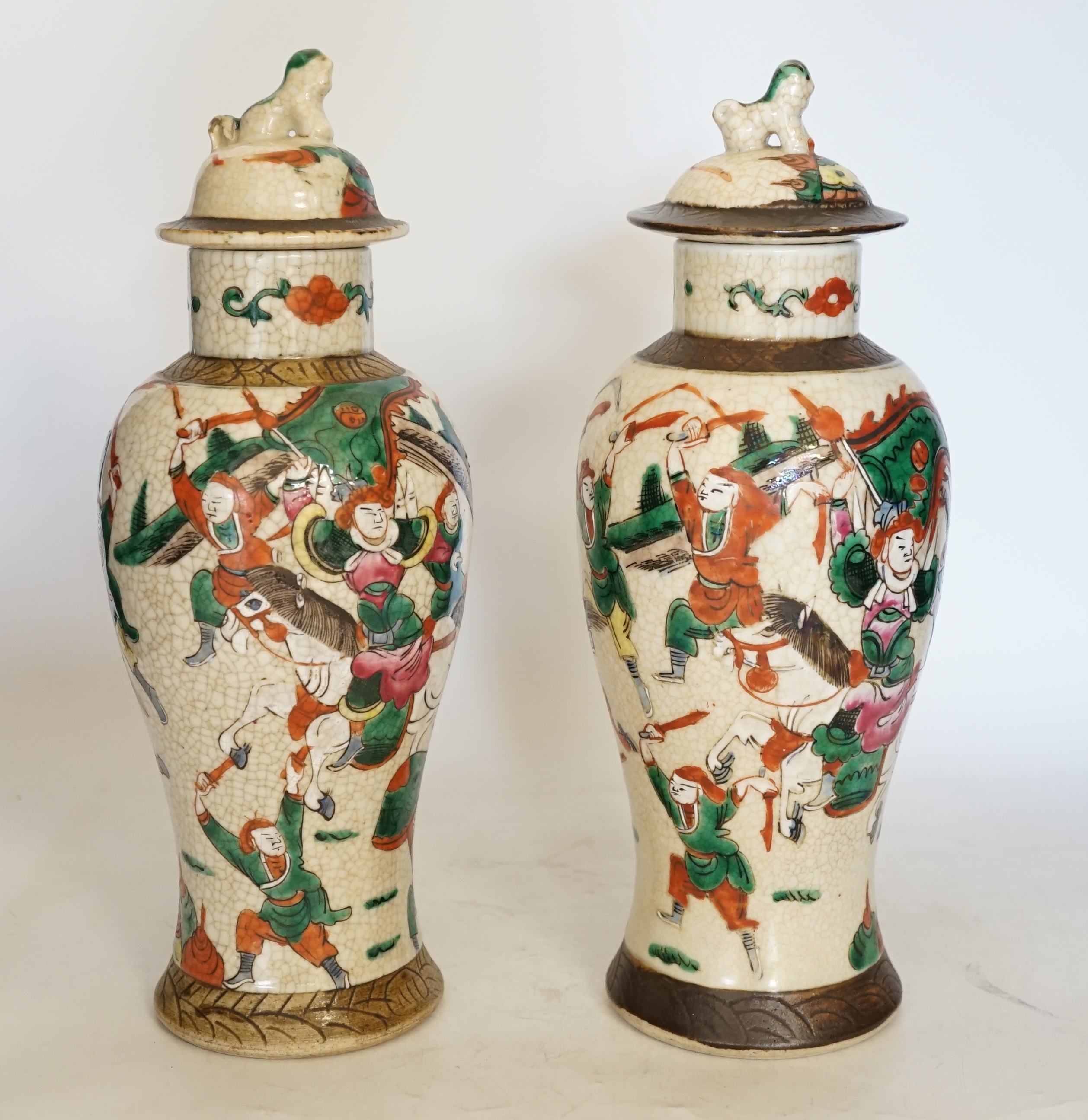 A pair of 19th century Chinese famille rose crackle glaze vases and covers, 31cm. Condition - fair to good